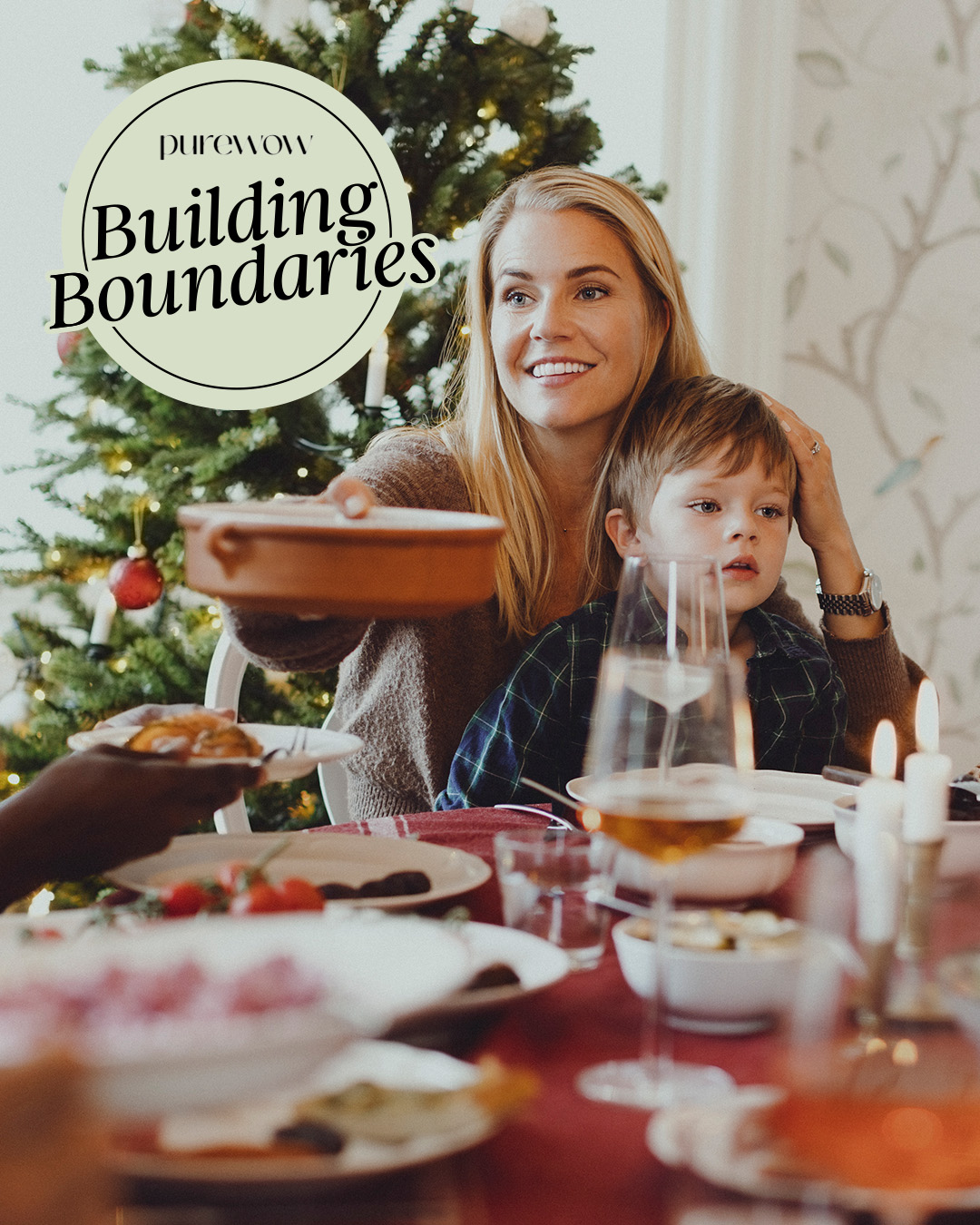 A mom holding a child in front of christmas tree passes a tray around